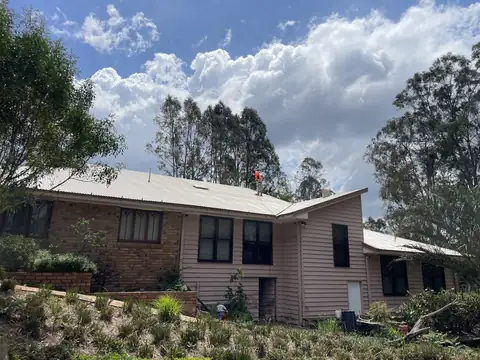 A brick house with a freshly painted roof
